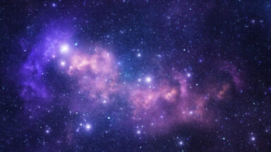 Image of a purple nebula speckled with stars against a dark backdrop.