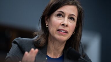 FCC Chairwoman Jessica Rosenworcel sits in front of a microphone while testifying during a Congressional hearing.