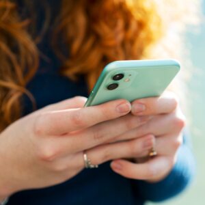 A woman holding a cell phone in her hands