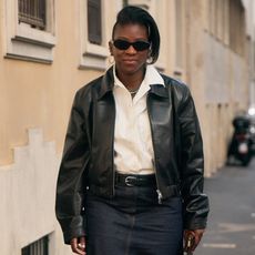 Nikki Ogunnaike wearing a leather jacket, white button down and denim skirt 