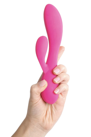 hand holding up pink rabbit vibrator on a white background