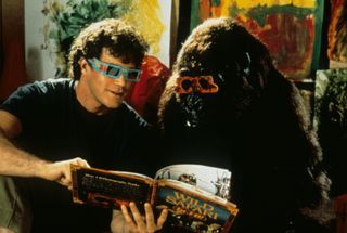 a man and a gorilla in 3d glasses reading a book together in the movie Congo