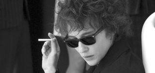 Cate Blanchett holds a cigareete and wears black sunglasses as Bob Dylan in 'I'm Not There'