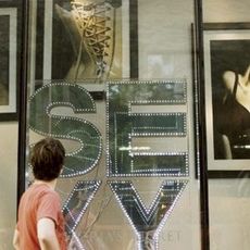 man looking at a storefront sign that says sexy