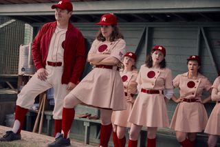 a group of women in vintage baseball uniforms in the dugout in the tv show a league of their own