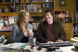 kate winslet and jack black sit at a desk smiling at each other in the holiday