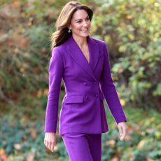 Kate Middleton wearing a purple trouser suit and smiling