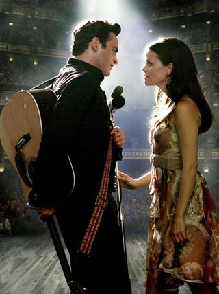 Joaquin Phoenix and Reese Witherspoon as johnny cash and june carter singing together on stage in 'Walk the Line'