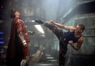 a man in cargo pants kicks at a man in royal like clothing in the movie Street fighter