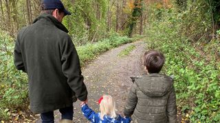 Edoardo Mapelli Mozzi, Sienna and Wolfie holding hands in a forest