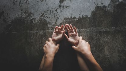 image of hands on top of other hands to suggest two people in an embrace