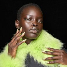 woman with green collar and nails showcasing minimized pores