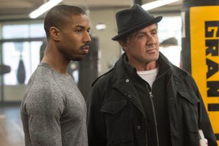 michael b jordan and sylvester stallone standing in a boxing gym in creed