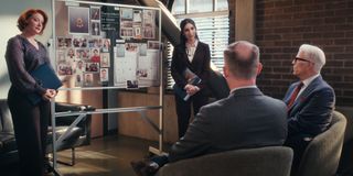 Two women (Kerry O’Malley as Megan and Lilah Richcreek Estrada as Julie) stand on either side of an investigation board in front of two men (Marc Evan Jackson as Evan Cubbler, Ted Danson as Charles) sitting in chairs, in episode 107 of 'A Man on the Inside.'