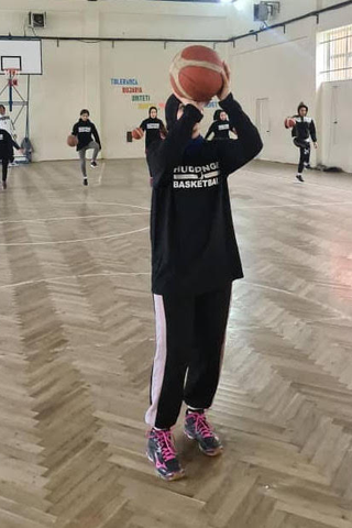 An Afghan refugee plays basketball in Albania, where she is waiting for a Visa