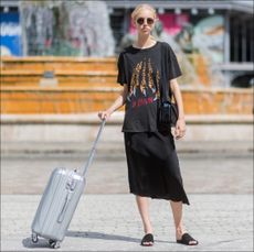 A model with a carry-on outside Sacai during Paris Fashion Week Menswear Spring/Summer 2018 Day Four on June 24, 2017 in Paris, France. (Photo by Christian Vierig/Getty Images)