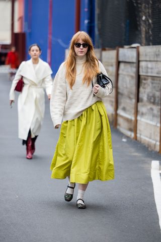 A woman walks at New York Fashion Week wearing Mary Janes with embroidery