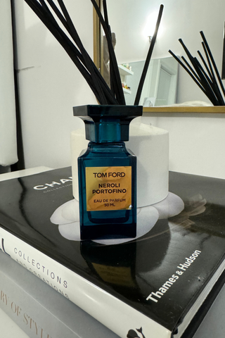 Tom Ford Neroli Portofino in front of a diffuser sitting on top of a Channel book.