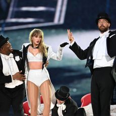 Taylor Swift and Travis Kelce on stage in black and white outfits during the Eras Tour