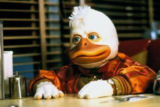 a giant duck puppet in a bomber jacket sits at a diner in the movie Howard the Duck