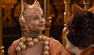 a white cat with a watch and pearls drapped around herself in the movie Cats