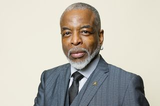 a promotional shot of lavar burton wearing a suit and tie