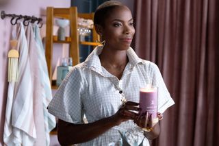 Jennifer Kale (Sasheer Zamata), holding a candle while standing in a boutique, in Marvel Television's AGATHA ALL ALONG, exclusively on Disney+.