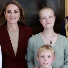 Kate Middleton wears a burgundy suit while meeting young photographer, Liz Hatton, who has a rare form of cancer