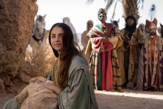 Noa Cohen as Mary holding a baby jesus while the wisemen watch on in the netflix movie mary