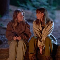 maisy stella and aubrey plaza as young and old elliott sitting on a log at a campfire in my old ass