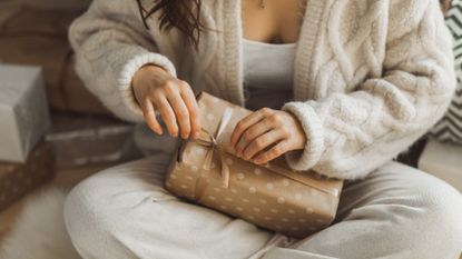 Close up of woman&#039;s hands unpacking holiday gift