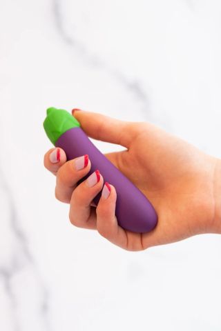 hand holding a small, eggplant-shaped bullet vibrator