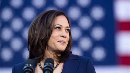 Kamala Harris smiling at a microphone