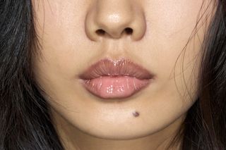 A woman with minimized pores and glossy lips.