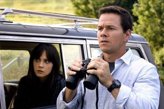 zooey deschanel looks concerned out of a car window and mark wahlberg holds binoculars in The happening