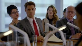 several girls sit behind men in a conference room in The Bold Type