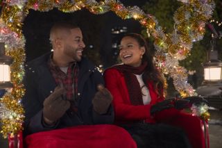 Devale Ellis as Teddy and Christina Milian as Layla riding in a festive cart through new york city in Meet Me Next Christmas