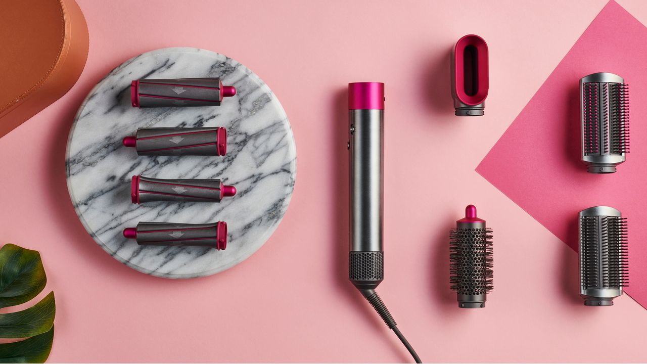 The Dyson AirWrap, one of the best hair curlers, on a pink and marble table