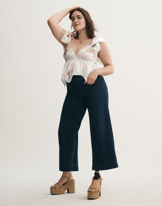 a woman wears anthropologie adaptive including wide leg jeans and platform sandals