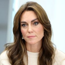 James Middleton with a beard and wearing a scarf and Kate Middleton wearing a cream sweater dress and looking sad, with long bouncy hair