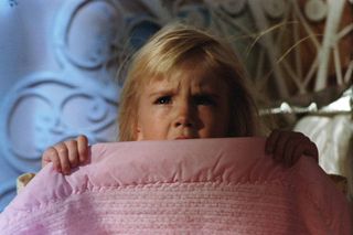 little girl hides under a blanket in Poltergeist