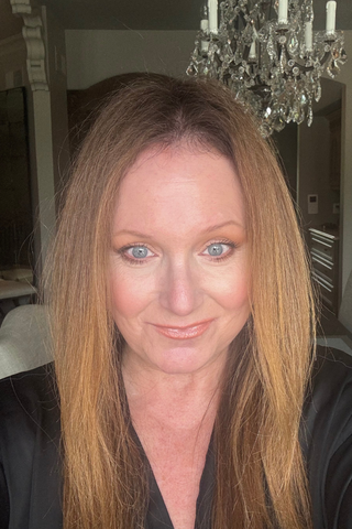 Mindy Holender wearing anastasia concealer in a black shirt.