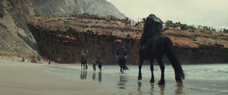 kingdom of the planet of the apes movie still of apes riding on horseback on the beach