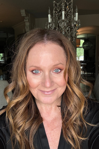 Mindy Holender wearing cle de peau concealer in a black shirt.