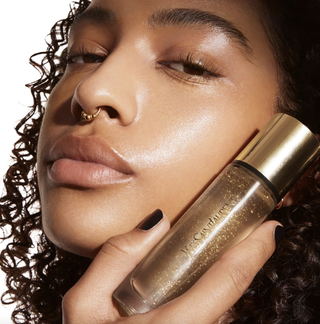 model with glowing skin holding the ysl face primer