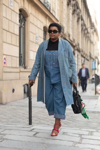 woman wearing overalls and a denim coat