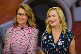 jenna fischer and angela kinsey wear dresses and sit smiling next to each other while promoting the podcast office ladies