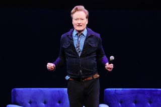 conan obrien speaking on stage at an event for his podcast conan obrien needs a friend