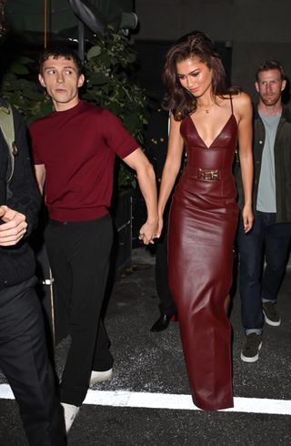 A photo of Zendaya and Tom Holland wearing matching burgundy ensembles