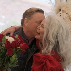 Suzanne (right) holds a bouquet of flowers as Avery (left) kisses her cheek, in 'The Later Daters.'